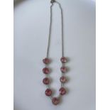 A vintage white metal art deco necklace fitted with 9 large pink cut stones [length 35cm]