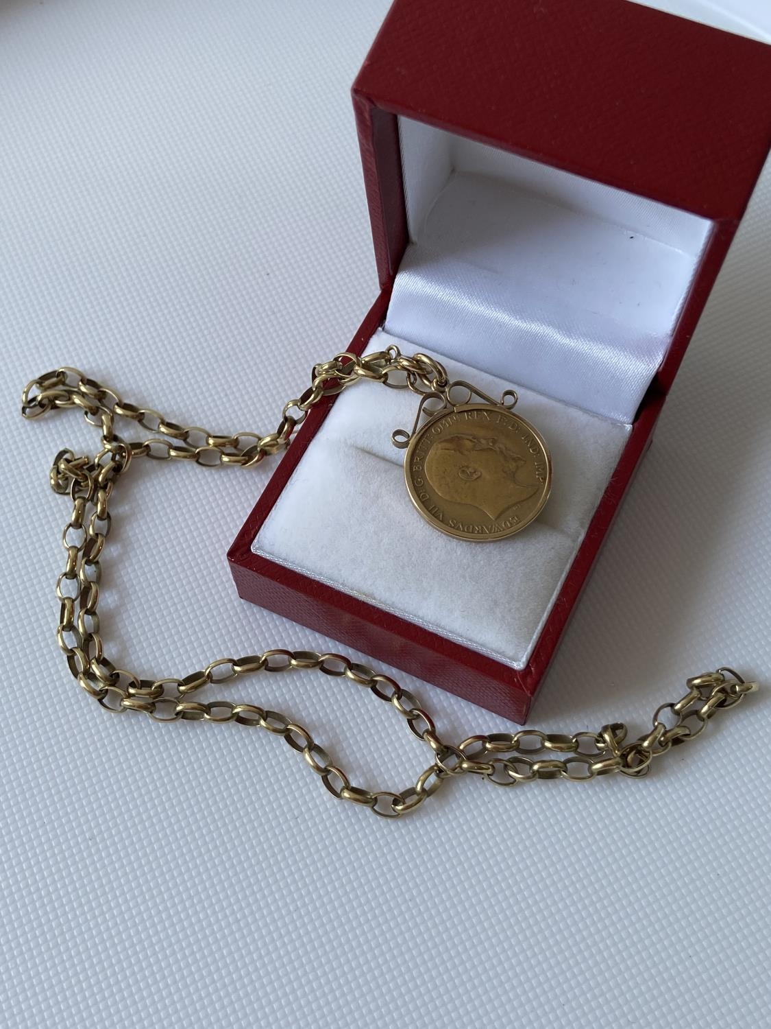 A 9ct gold 1/2 sovereign, dated 1905, with a 9ct gold casing and a 9ct gold belcher chain [length