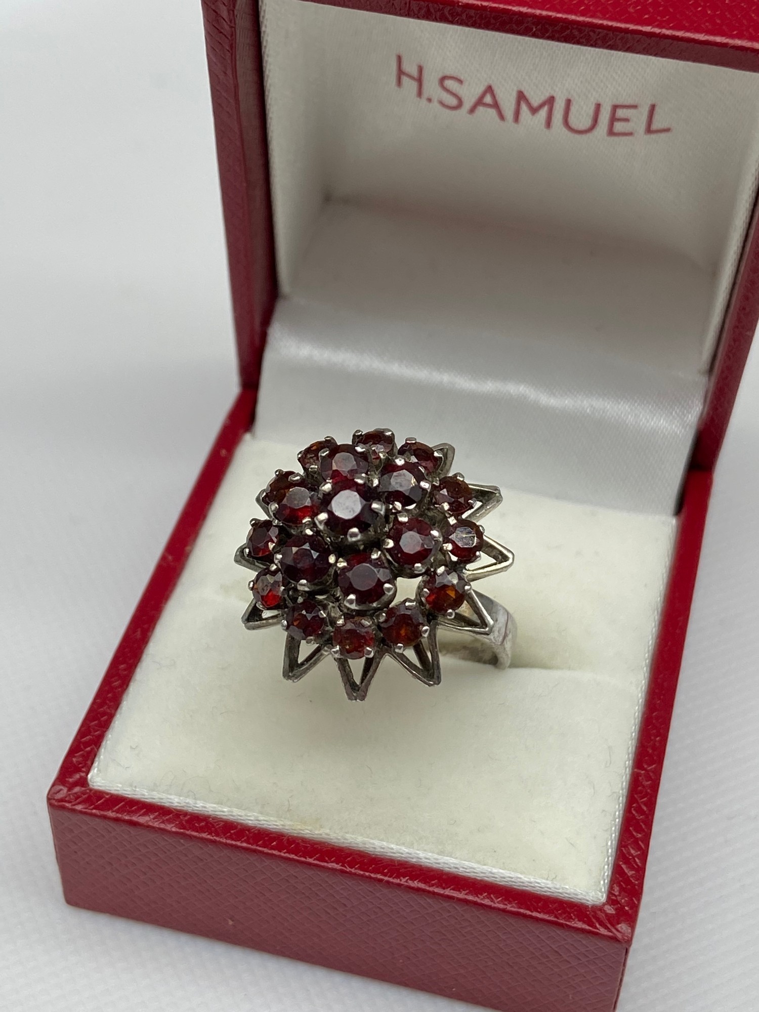 A Ladies silver and garnet cluster ring. [Ring size M]