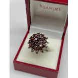 A Ladies silver and garnet cluster ring. [Ring size M]