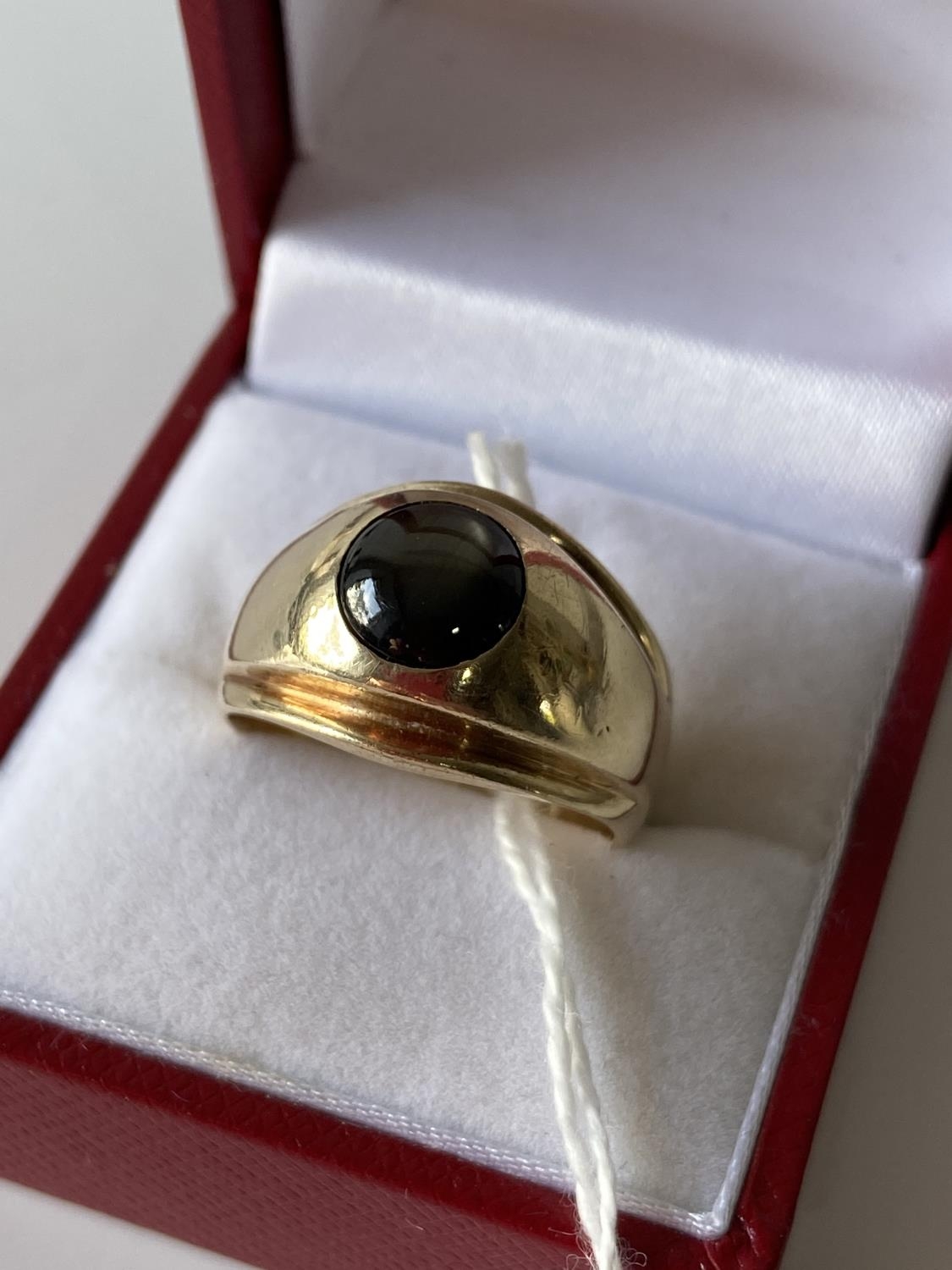 An 18ct gold gents ring set with a single star sapphire/ Cats eye style stone. [size 0] [9.86g]