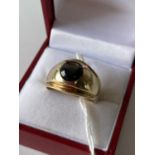 An 18ct gold gents ring set with a single star sapphire/ Cats eye style stone. [size 0] [9.86g]