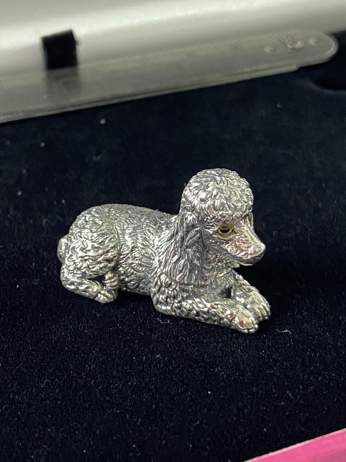 A Silver figure of a poodle dog. [3.2cm in length]