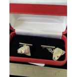 A Pair of silver salmon headed cufflinks with ruby eyes.