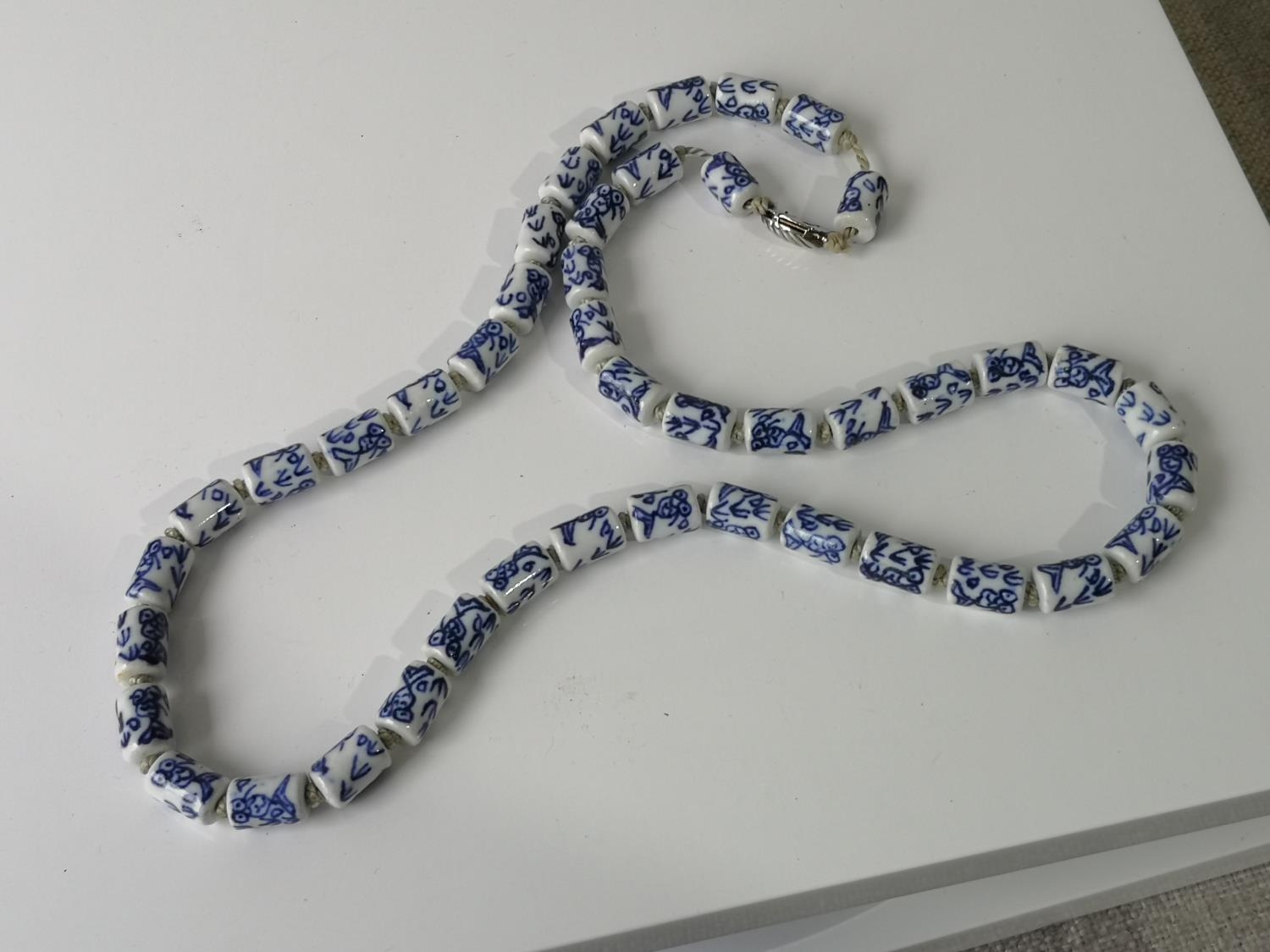 A CHINESE BLUE AND WHITE CERAMIC BEAD NECKLACE