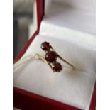 A ladies 18ct gold twist ring set with 3 large garnets [size L] [2.78g]