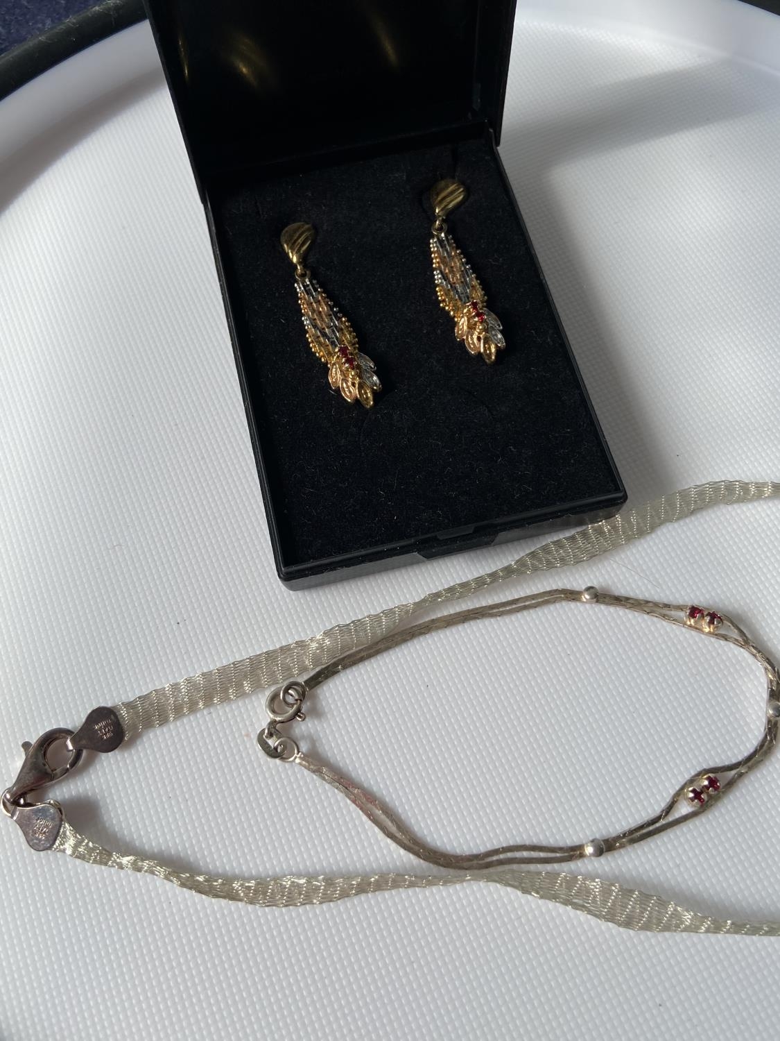 A pair of ornate 925 silver two tone clip-on earring set with garnets, silver bracelet with