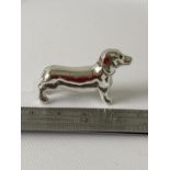 A Silver sausage dog figure. [3.8cm in length]