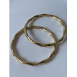 A pair of 9ct gold dolphin design bangles [9.95g]