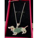 A Silver pendant necklace in the form of a sausage dog. [4.5cm nose to tail]