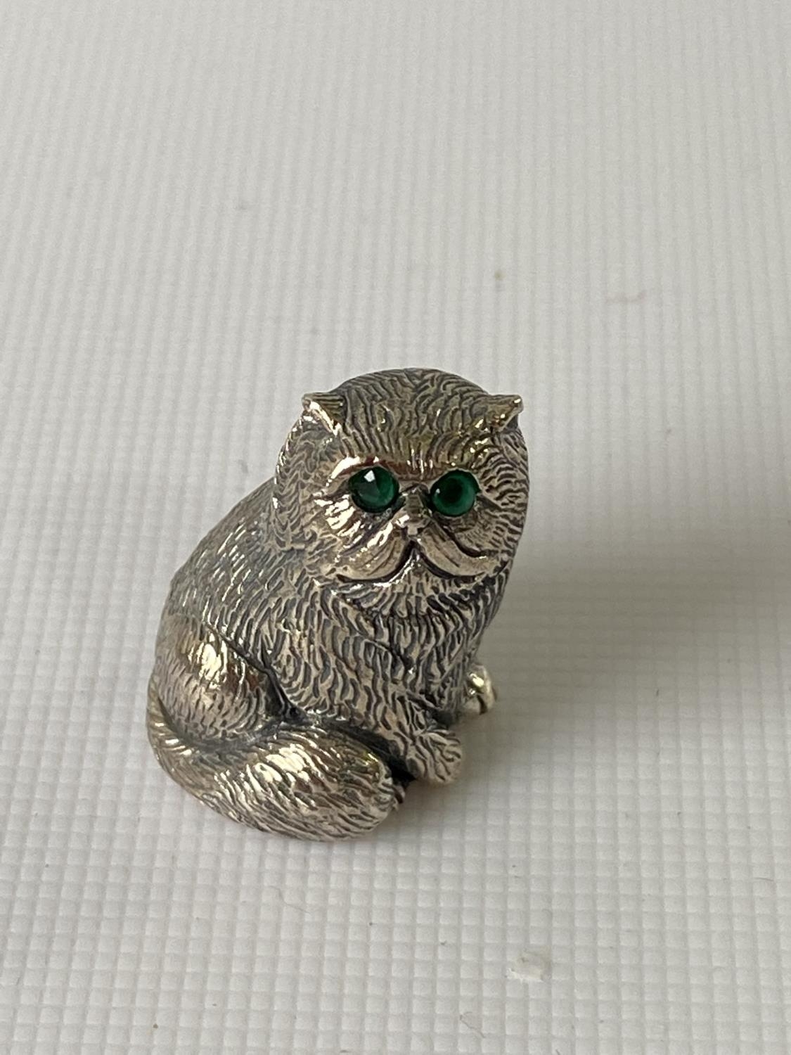 A silver figure of a cat with emerald eyes. [2.3CM IN HEIGHT]