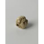 A Japanese Meiji period hand carved Ojime bead of three dogs huddled together. [1.9cm in diameter]