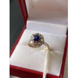 A 9ct gold ladies ring set with a single sapphire surrounded by clear cut stones [size J] [2.68g]