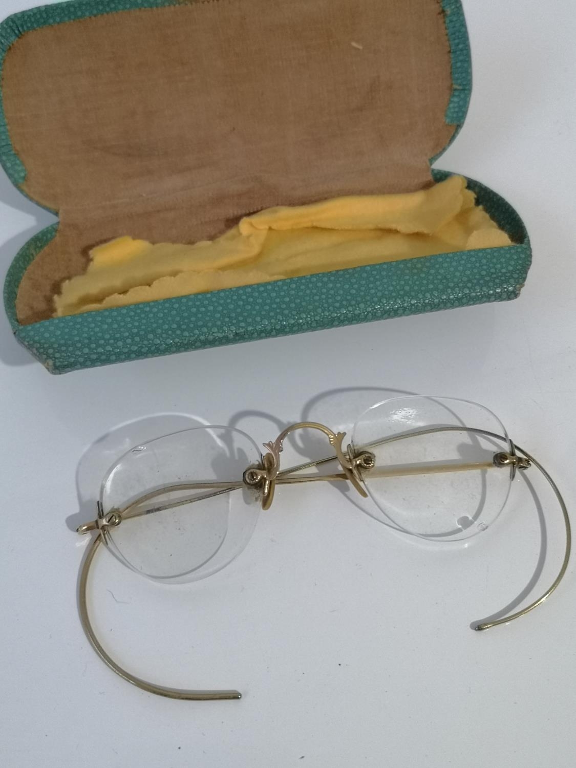 A SET OF VINTAGE GOLD COLOURED SPECTACLES WITH PROTECTIVE CASE.