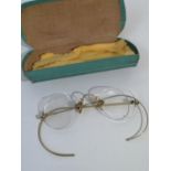 A SET OF VINTAGE GOLD COLOURED SPECTACLES WITH PROTECTIVE CASE.
