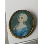 A 19th century miniature lady portrait within a gilt metal surround brooch. [6x5.1cm]