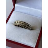 A 9ct gold band ring set with clear stones [size N] [3.45g]