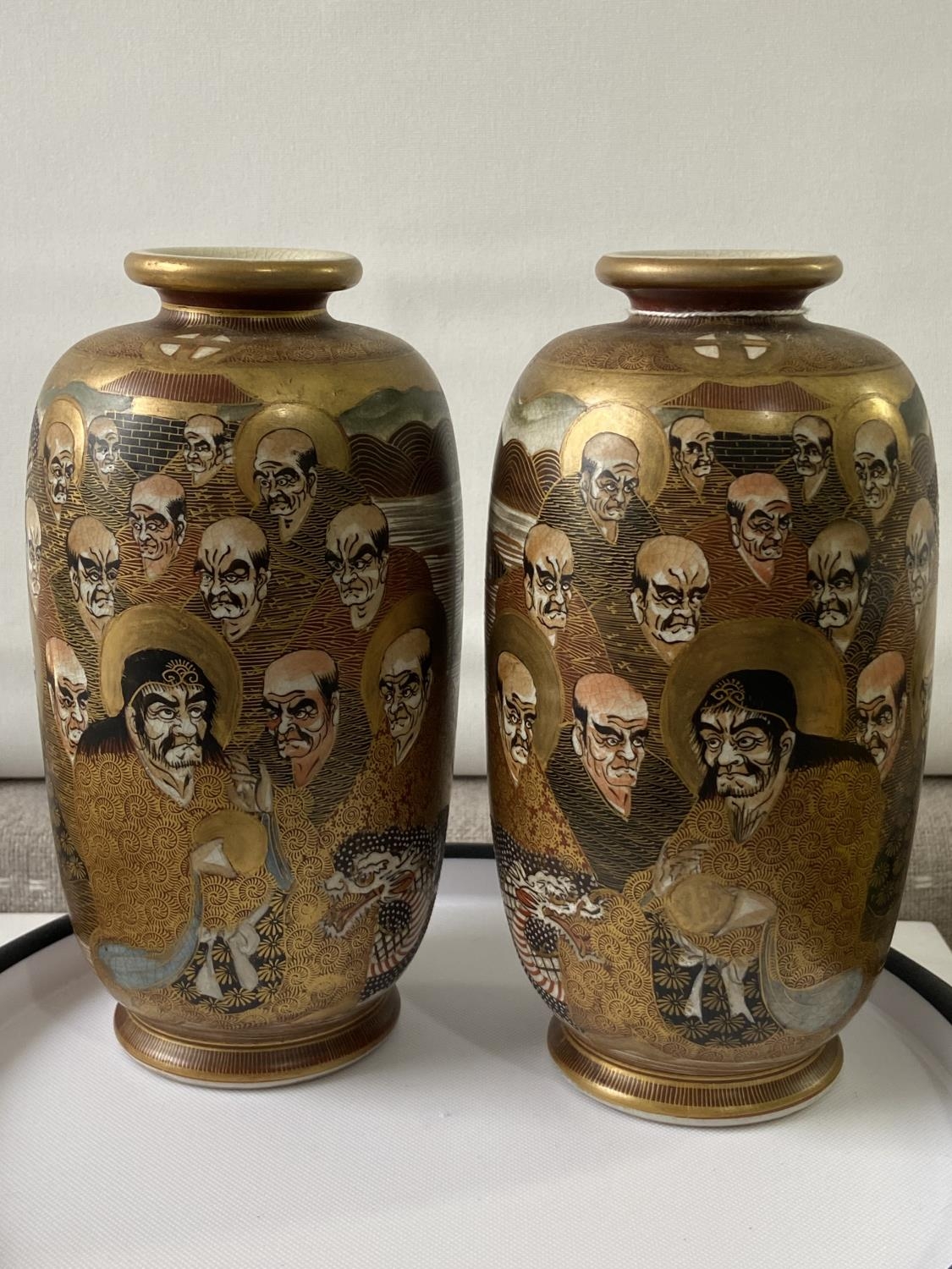 A pair of Japanese satsuma hand painted vases depicting various characters & dragon design [height