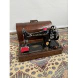 A vintage Singer sewing machine, complete with wooden fitted case