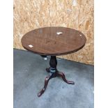 A mahogany circular flip top table supported on a tri leg [height, 67cm, diameter, 61cm]