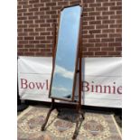 An antique mahogany framed, full-length mirror with bevel edge, upon brass castors [163 x 42cm]