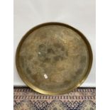 A Large gilt brass engraved Indian wall charger/ table top. [diameter 62cm]