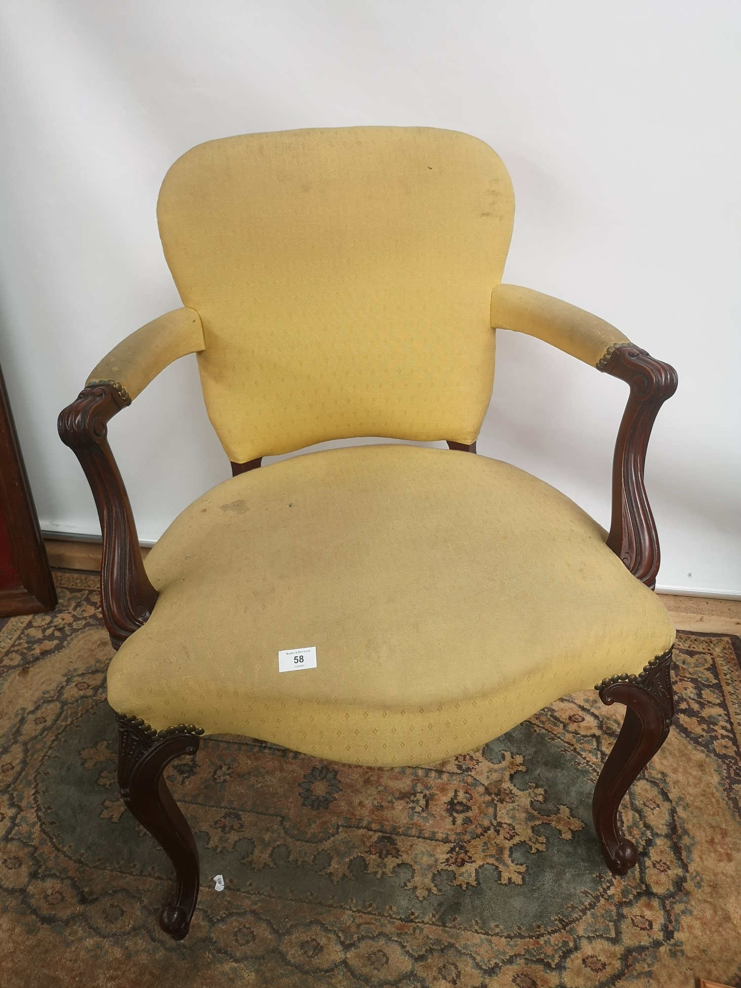 A Victorian arm chair, open scroll arms, supported on cabriole legs and ending in scroll feet [