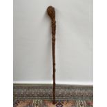 A hand carved walking stick, unusually carved with bats, thistles & snake [length,75cm]