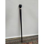 An antique ebony walking cane with a carving to the handle depicting a hand [length 85cm]