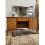 A Retro pedestal knee hole dressing table. Fitted with 7 drawers and a three way mirror. Produced by