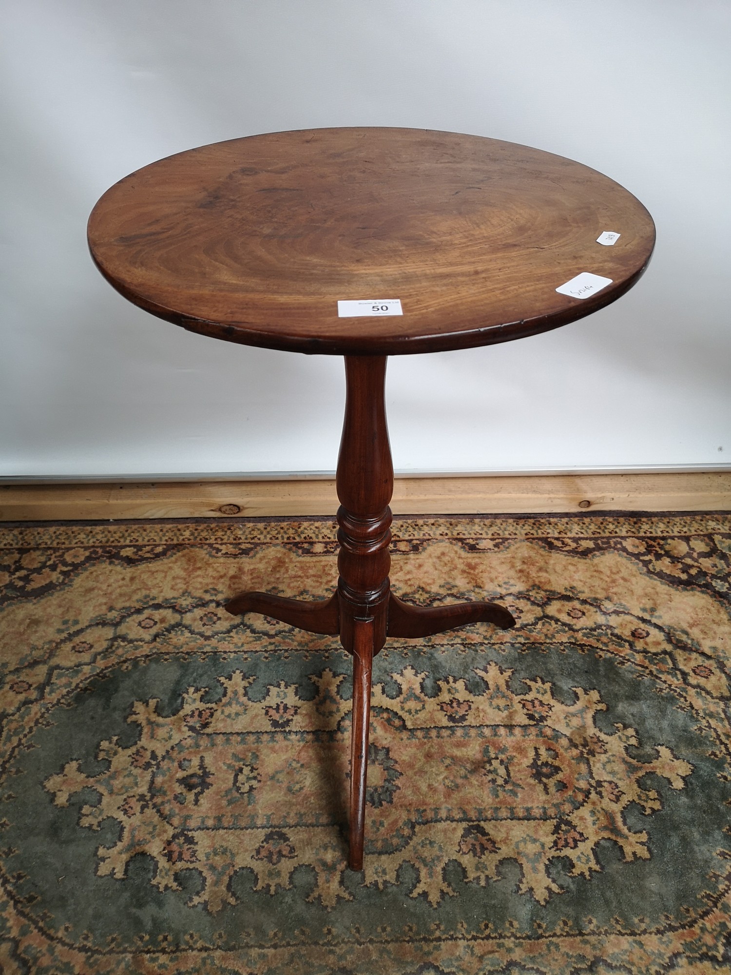 A Georgian pedestal table with circular top, supported on a tripod vase