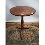 A Georgian pedestal table with circular top, supported on a tripod vase