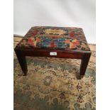 A 19th century mahogany stool, supported on four tapered legs upon castor feet [length, 43cm,