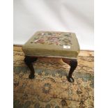 A Victorian square stool, supported on four Queen Anne legs, upholstered in a floral tapestry [