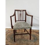 A Georgian arm chair, with channel carved arms, supported on tapered legs with a middle stretcher,