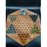 A vintage solitaire marble game. Designed with 6 matching sets of marbles. [Wooden board measures