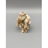 An Early 20th century Japanese hand carved bone netsuke of gentleman carrying a sack on his back.