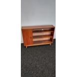 A Mid century teak bookcase with glass sliding doors. [73x107x26cm]