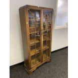 An Art Deco 2 door display cabinet designed with an oak body and glass section doors.[169x83.5x30cm]