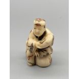 An Early 20th century Japanese Bone carved Netsuke of a gentleman seated. Signed. [5.2cm in height]