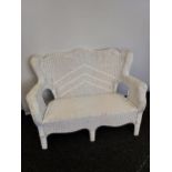 An Antique wicker weaved two seat garden/ patio chair.