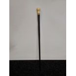 A 19TH century gentlemans walking cane with an ivory and yellow metal band handle. [85cm in length]