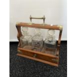 Antique wood and metal bound tantalus to include three decanters.