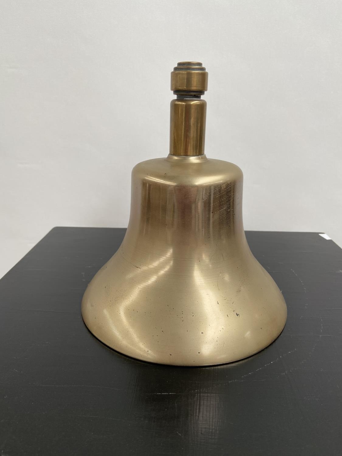 A Heavy antique hand bell. Stamped Greenberg to the inside. [Height 21cm, diameter 19cm]