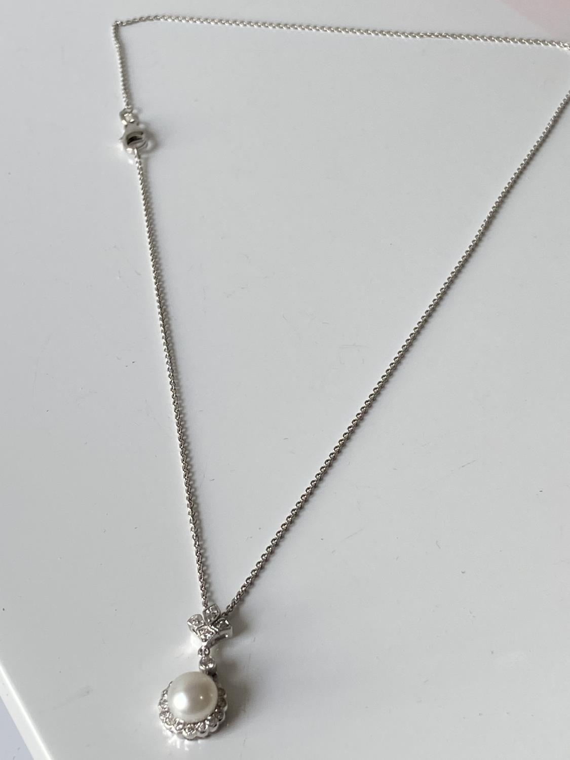 An 18ct white gold diamond cluster & single pearl pendant with an 18ct gold necklace [length