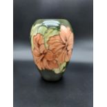 A Moorcroft Hibiscus design vase. Designed with a green ground base colour. Impressed marking to the