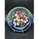 A Moorcroft Frescia design plate. Flowers on a green and blue ground back, Impressed and signed to