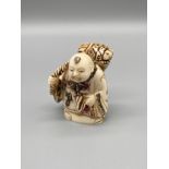An early 20th century Japanese hand carved bone netsuke of a gentleman carrying a basket on his