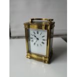 An Antique heavy brass and glass carriage clock. In a working condition with key. [12x8x6.5cm]