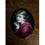 An Antique oval porcelain plaque depicting a young girl praying. Possibly hand painted. [18x14cm]